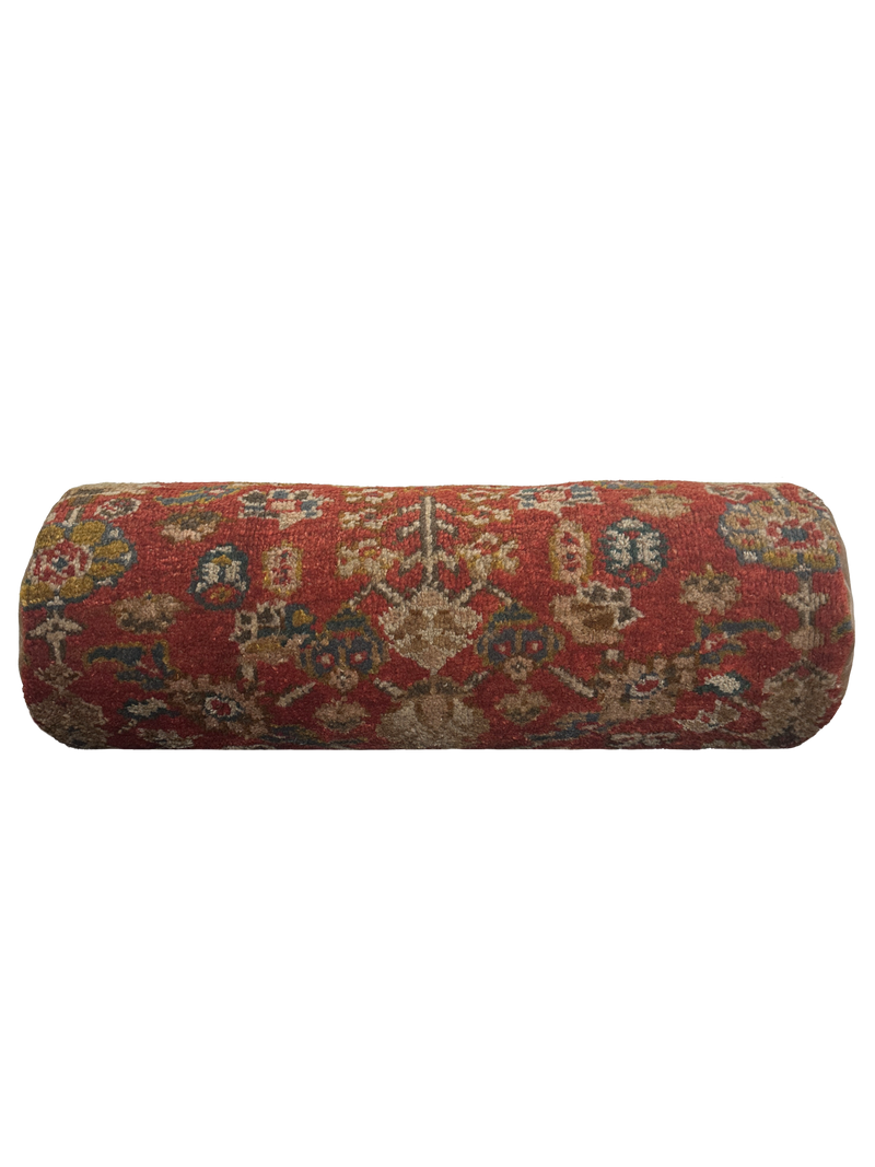 a large bolster cushion made from antique rug with cotton velvet ends