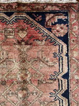 a mini hamadan rug, almost perfectly square in proportion with a coral field, a taupe floral pattern and a near black border