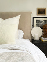 a cream lumbar pillow in white shearling