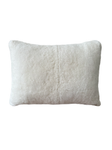 a cream lumbar pillow in white shearling