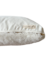 a cream lumbar pillow in shearling, backed with plush velvet with a brass zipper
