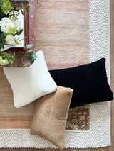 a white shearling pillow backed in plush velvet, with an exposed brass zipper