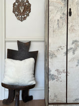 a white shearling pillow backed in plush velvet, with an exposed brass zipper