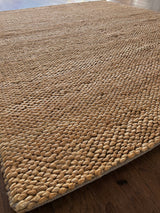 a chunky braided jute rug with ombre caramel tones