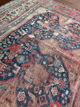 an antique qashqai rug with a blue field and small animal motifs