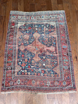 an antique qashqai rug with a blue field and small animal motifs