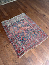 an antique qashqai rug with a blue field and small animal motifs