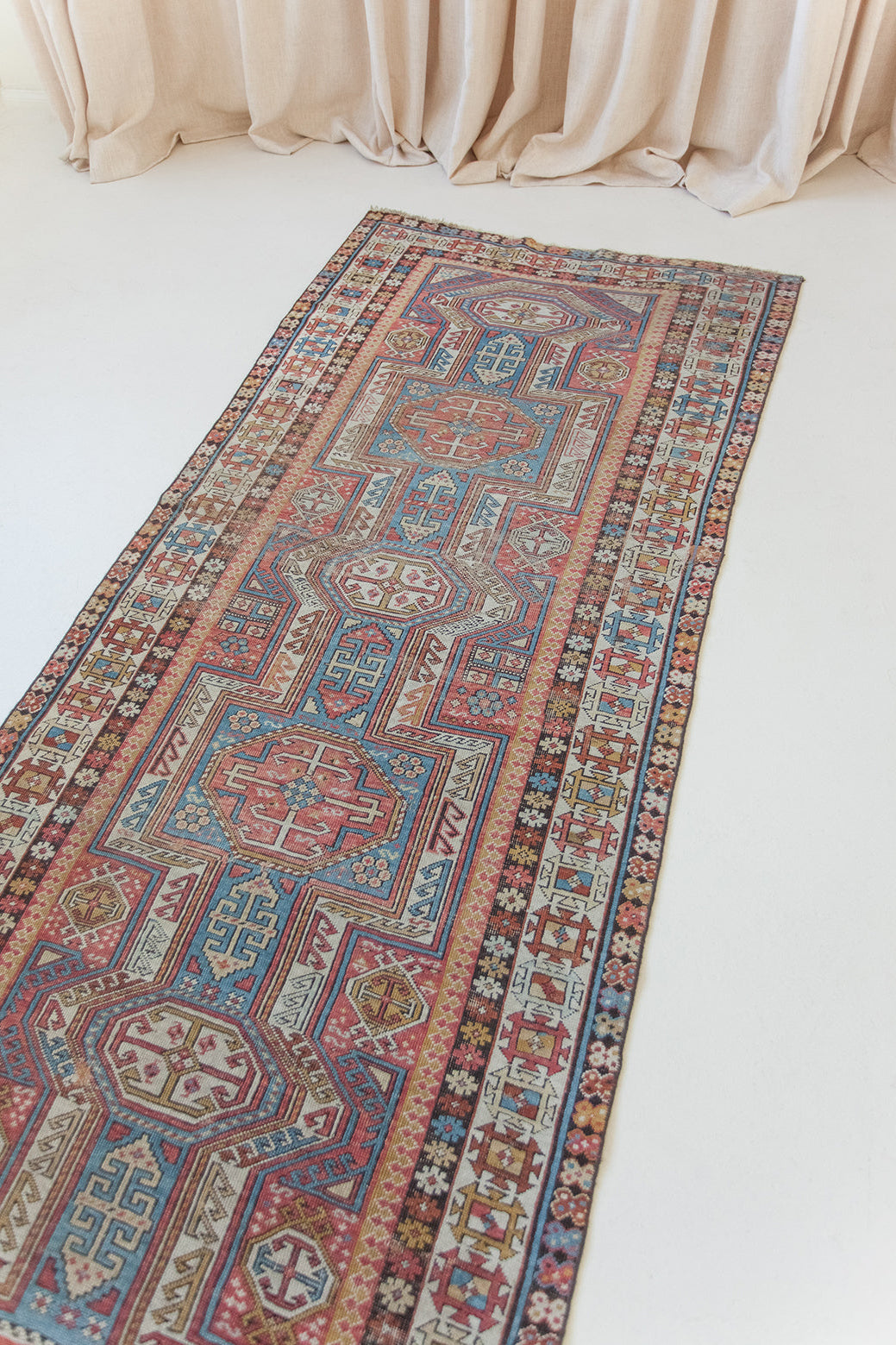 Decorative rug with intricate patterns on a white floor