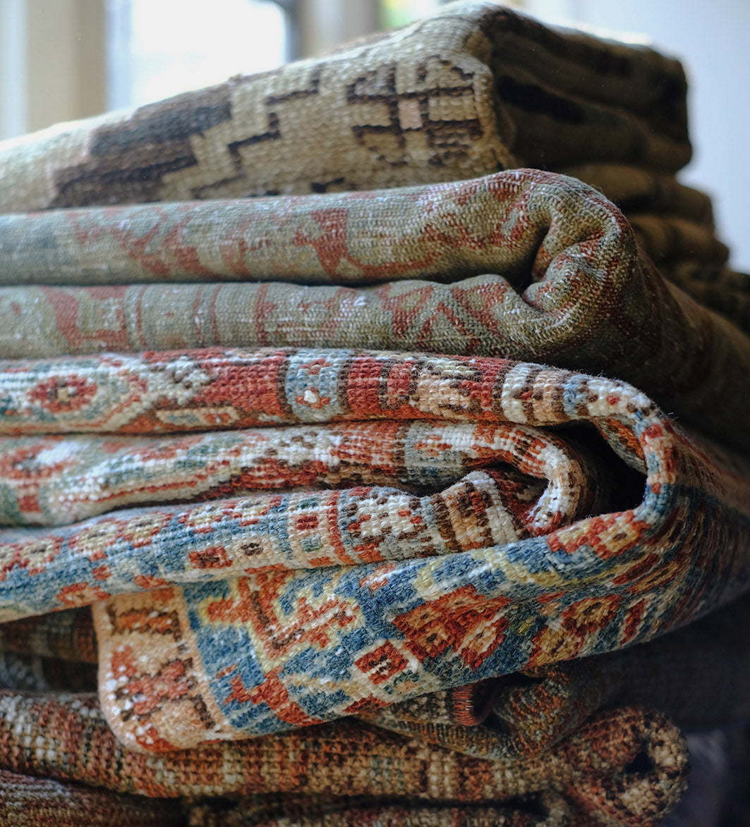 Stack of patterned rugs with intricate designs
