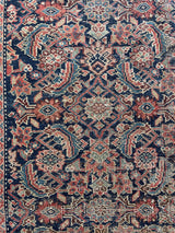 an antique malayer rug with a classic dark blue field and coral pink floral trellis design 