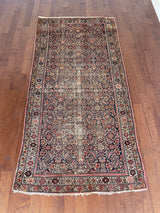 an antique malayer rug with a classic dark blue field and coral pink floral trellis design 