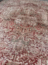 an antique heriz rug with ivory and pink accents and a light turquoise border