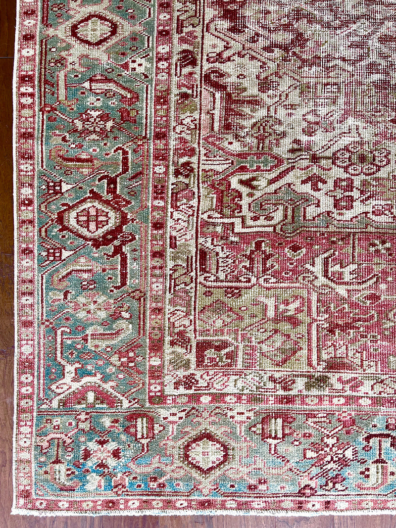 an antique heriz rug with ivory and pink accents and a light turquoise border