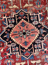 a large antique heriz rug with a red field and midnight blue medallion