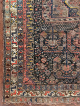 an antique shiraz rug with midnight field and yellow and pink accents