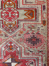 an antique caucasian shirwan rug with a silver lilac field and bright pink accents