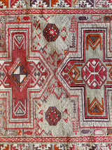 an antique caucasian shirwan rug with a silver lilac field and bright pink accents