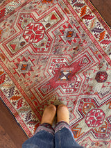 an antique caucasian shirwan rug with a silver lilac field and bright pink accents