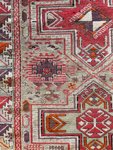 an antique caucasian shirwan rug with a silver lilac field and bright pink accents