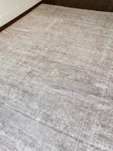 a large faded oushak rug with a soft dusty pink palette and fawn details