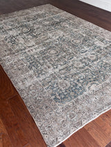 a large antique tabriz rug with a blue green field and subtle floral details