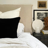 a black shearling lumbar with a plush velvet backing and exposed brass zipper