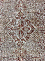 an antique persian kosakan rug with a grey/green field and oxblood accents