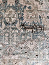 a vintage malayer rug with a teal field and detailed deer motifs 