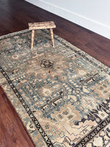 a vintage malayer rug with a teal field and detailed deer motifs 