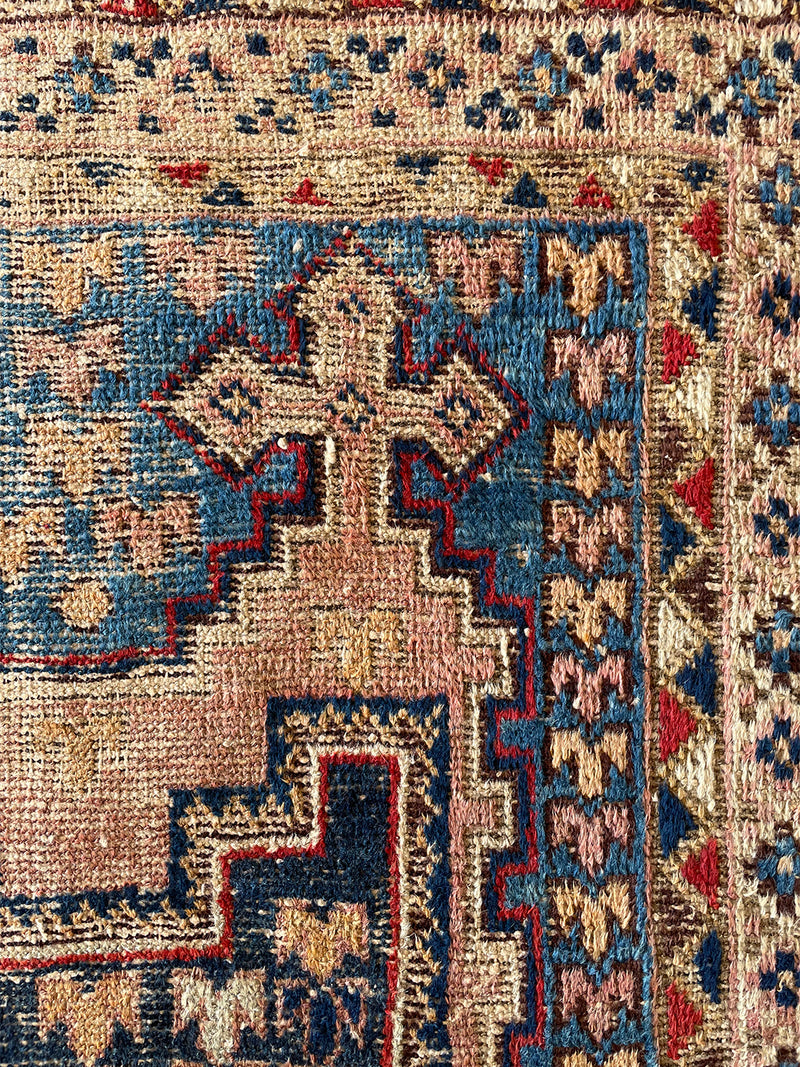 an antique-afshar-rug-with pink and blue details and two cream central medallions