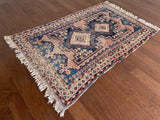 an antique-afshar-rug-with pink and blue details and two cream central medallions