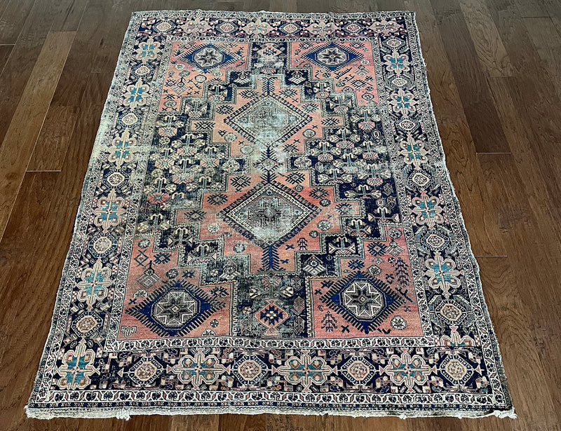 an antique afshar rug with a coral field, pink abrash and dark blue accents