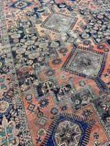 an antique afshar rug with a coral field, pink abrash and dark blue accents