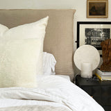 a white shearling pillow backed in plush velvet, with an exposed brass zipper