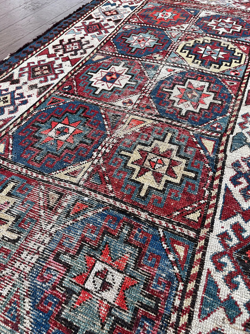 an antique kazak runner with geometric pattern in red, blue and green
