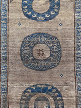 an antique khotan rug with a camel field and a border border and central medallions