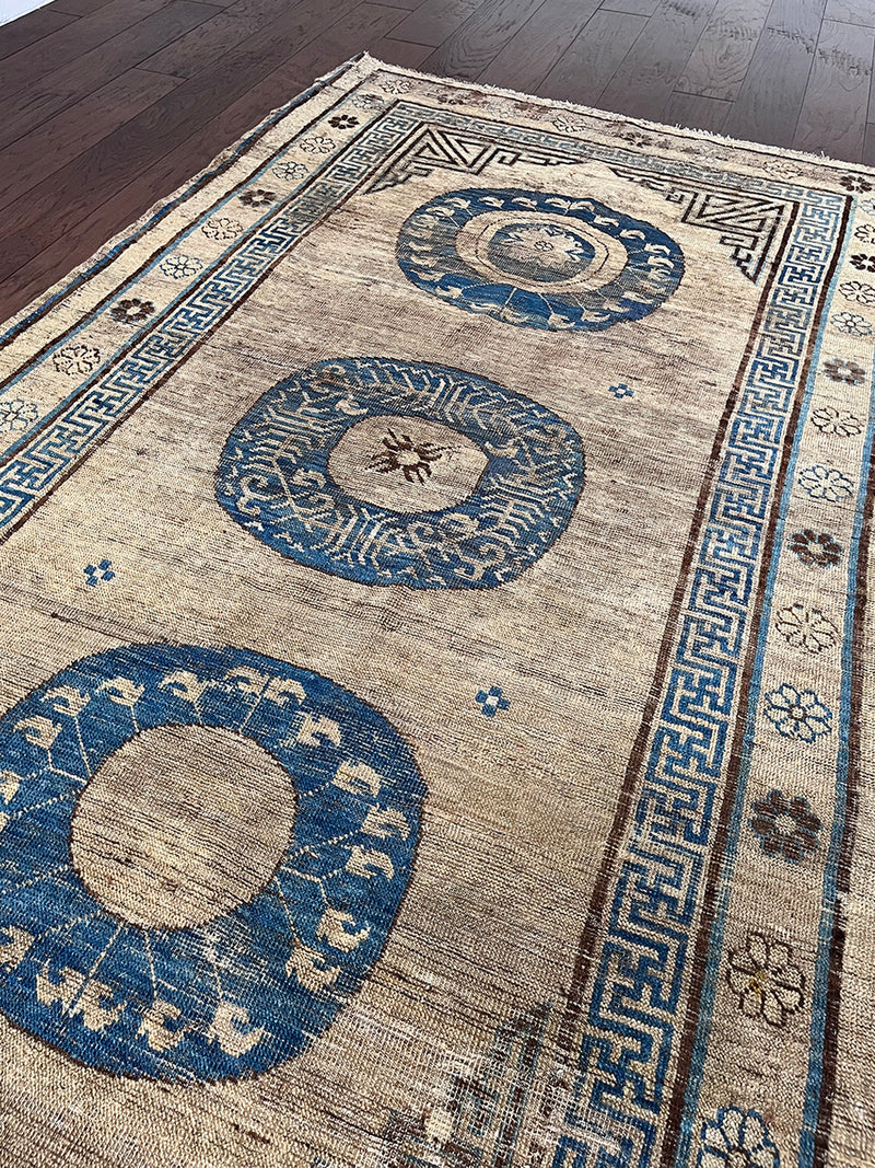 an antique khotan rug with a camel field and a border border and central medallions