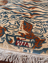 a vintage chinese rug with a large graphic tiger design in blue and burnt orange stripes