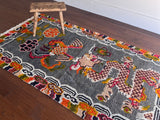 a vintage tibetan rug with a silky grey and field and a bright orange and coral dragon motif