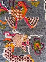 a vintage tibetan rug with a silky grey and field and a bright orange and coral dragon motif