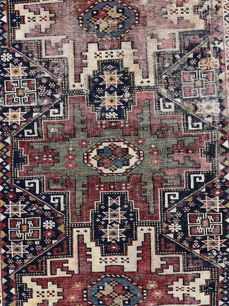 an antique caucasian shirwan rug with a midnight blue field and earthy terracotta accents