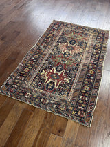 an antique caucasian shirwan rug with a midnight blue field and earthy terracotta accents