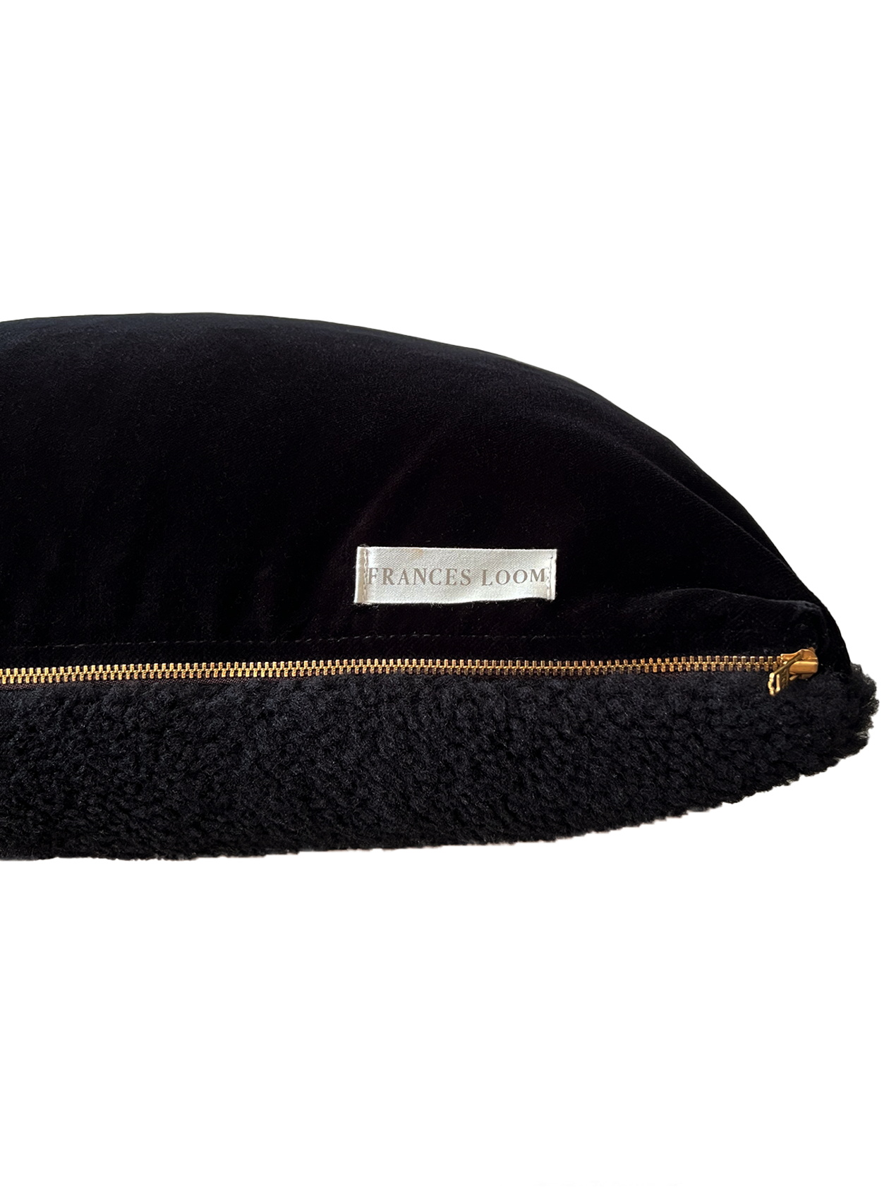 a black shearling lumbar with a plush velvet backing and exposed brass zipper