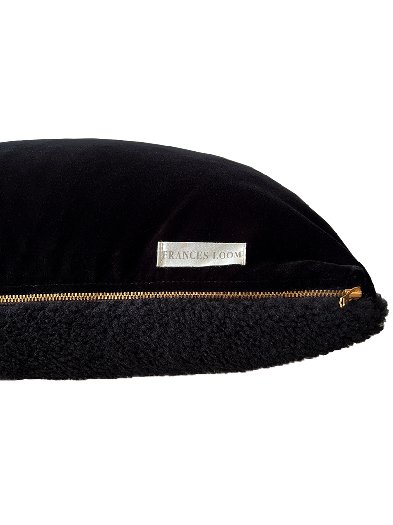 a black velvet pillow in shearling with a plush velvet backing and exposed brass zipper