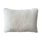 a cream lumbar pillow in white shearling