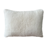 a cream lumbar pillow in white shearling