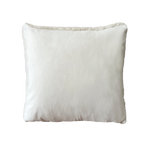 a white shearling pillow backed in plush velvet, with an exposed brass zipper