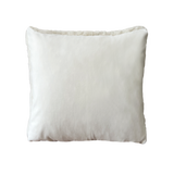 a white shearling pillow backed in plush velvet, with an exposed brass zipper