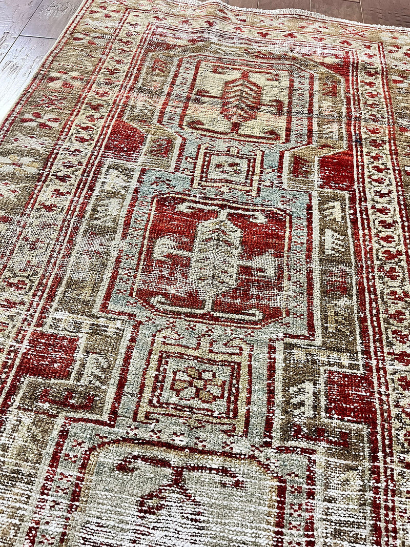 a beautiful antique heriz karajah runner with a brown and brick red palette and lemon yellow accents