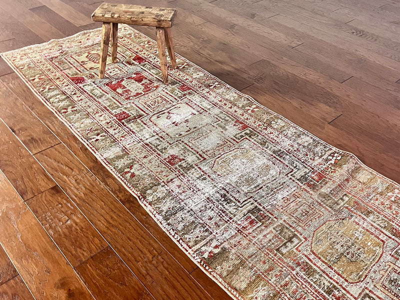 a beautiful antique heriz karajah runner with a brown and brick red palette and lemon yellow accents